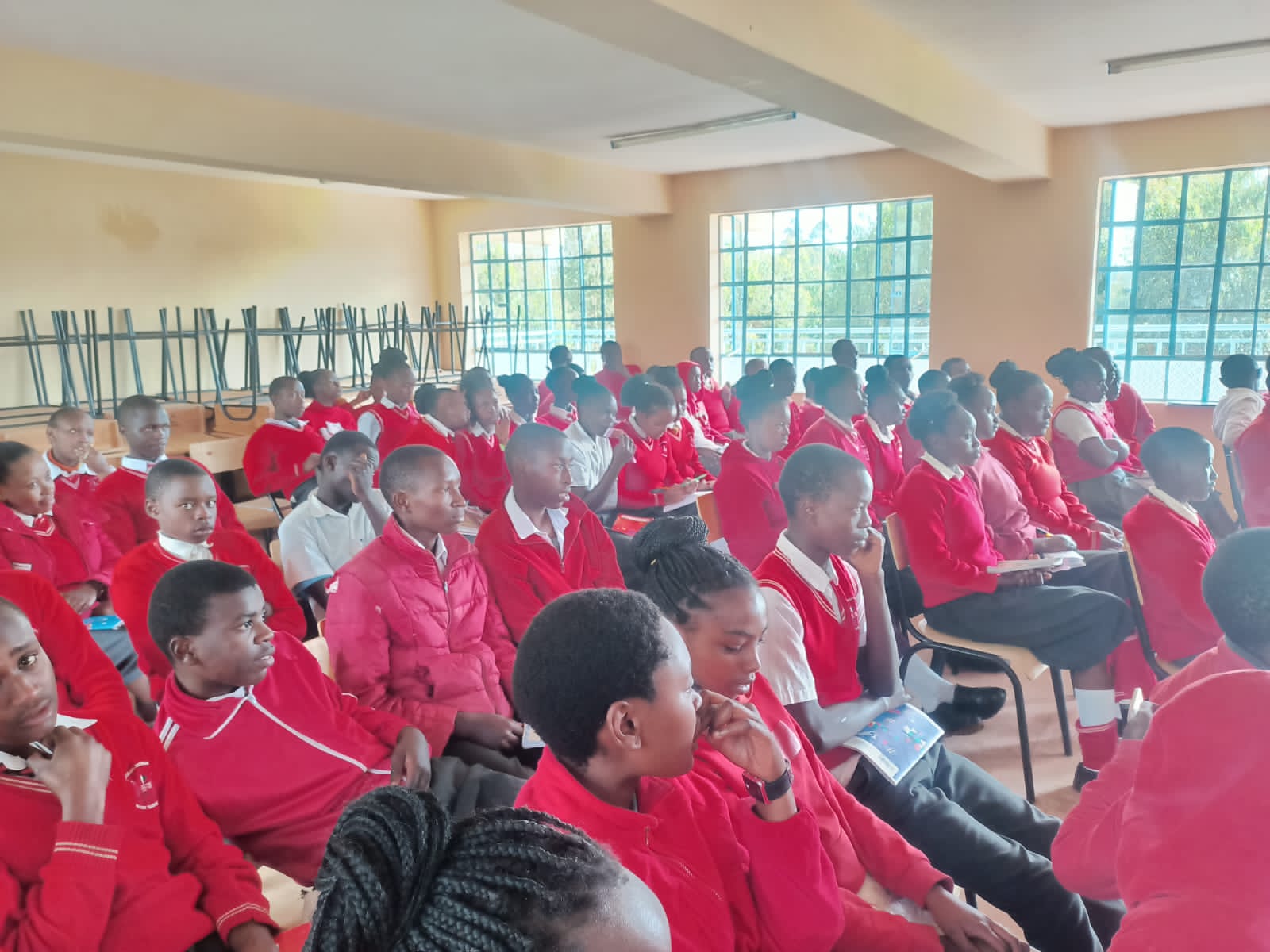A group of students in a classroom setting, listening to a presentation.